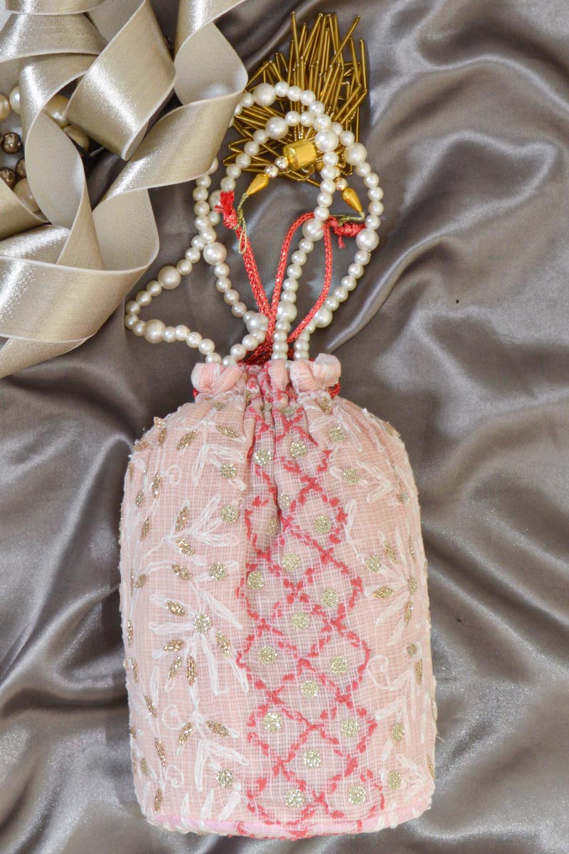 Fabnuma Handcrafted Pink Chikankari Potli Bag with intricate embroidery and pearl handle on satin fabric background.