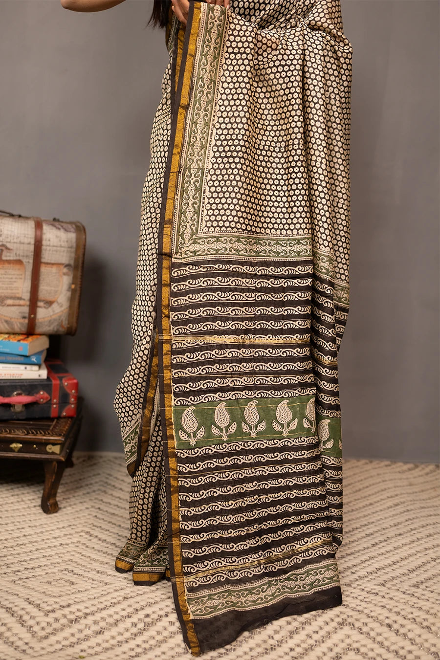 Woman wearing a patterned saree with a grey background