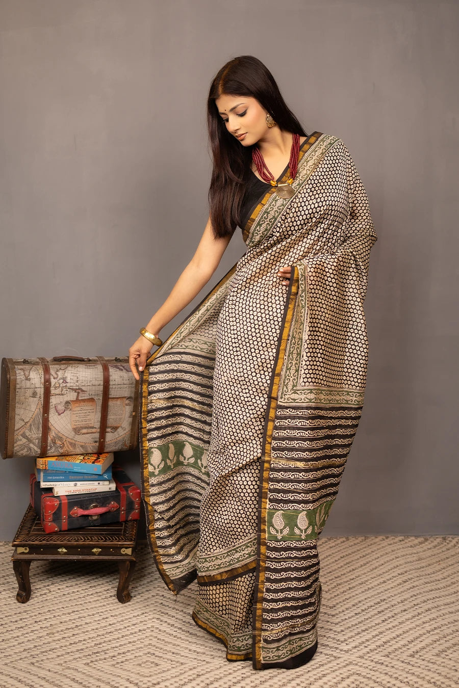 Woman wearing a patterned saree with a grey background