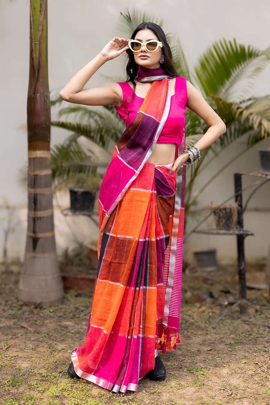Model wearing a multicolor linen checks saree in pink, orange, and purple, lightweight and suitable for casual, office, and festive wear.