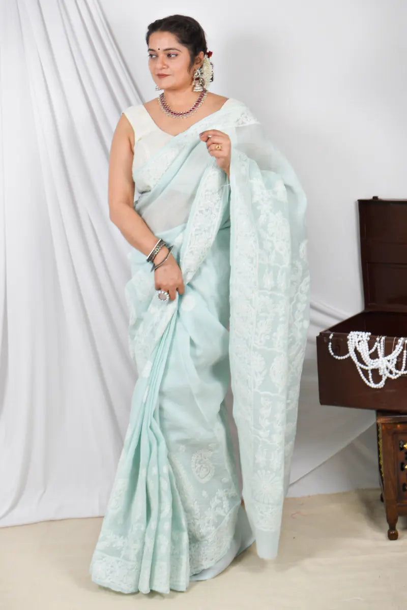 Handcrafted Pestal Blue Cotton Designer saree with intricate Lucknowi Chikankari embroidery and a matching blouse, ideal for festive and wedding occasions.