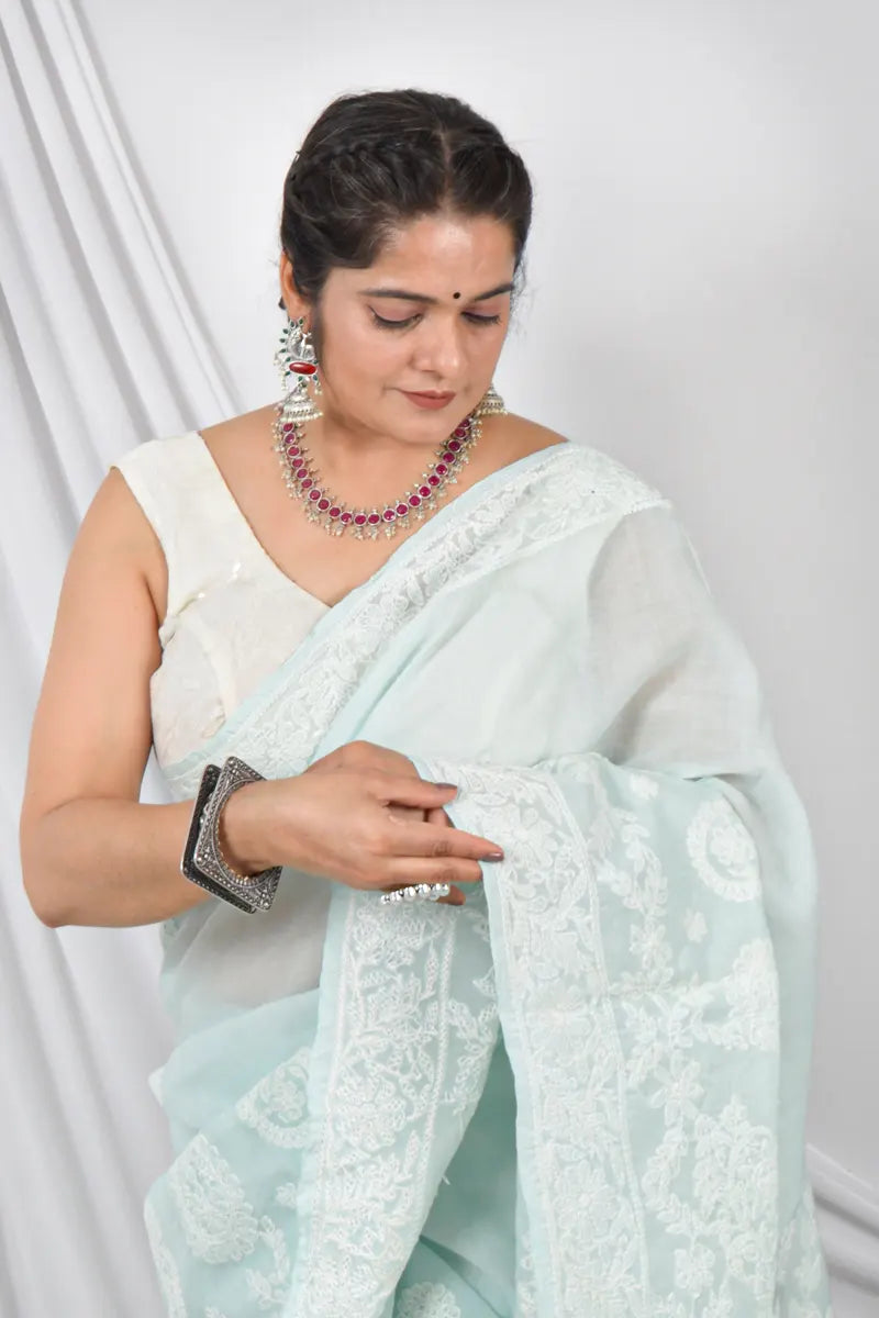 Handcrafted Pestal Blue Cotton Designer saree with intricate Lucknowi Chikankari embroidery and a matching blouse, ideal for festive and wedding occasions.