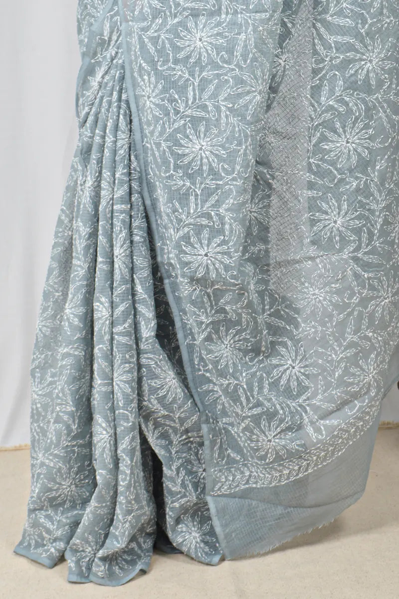 Light blue saree with white floral patterns on a plain background