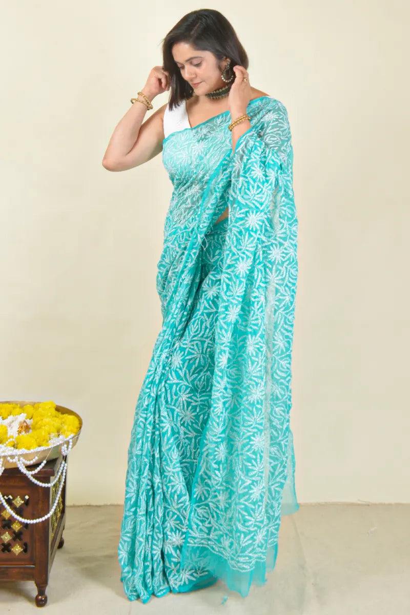 Handcrafted Aqua Blue Georgette Tepchi Work saree with intricate Lucknowi Chikankari embroidery and a matching blouse, ideal for festive and wedding occasions.