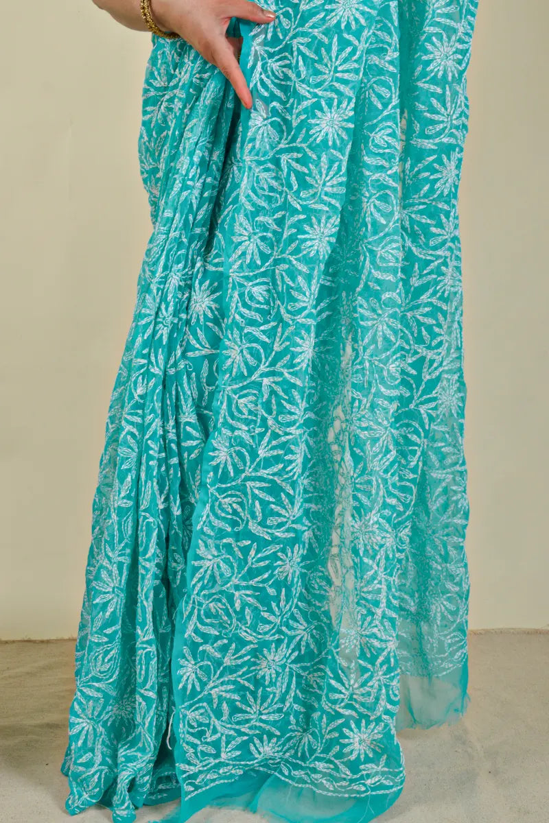 Handcrafted Aqua Blue Georgette Tepchi Work saree with intricate Lucknowi Chikankari embroidery and a matching blouse, ideal for festive and wedding occasions.