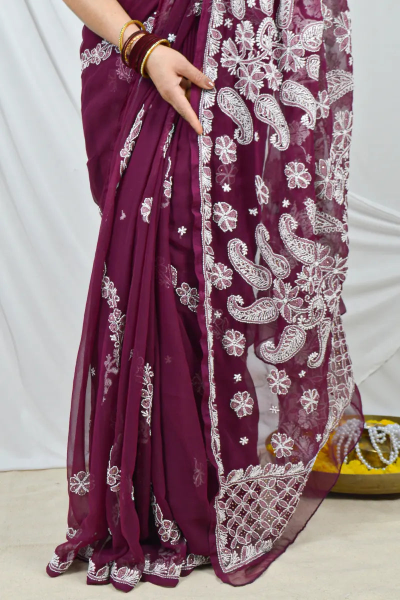 Handcrafted Wine Georgette saree with intricate Lucknowi Chikankari embroidery and a matching blouse, ideal for festive and wedding occasions.
