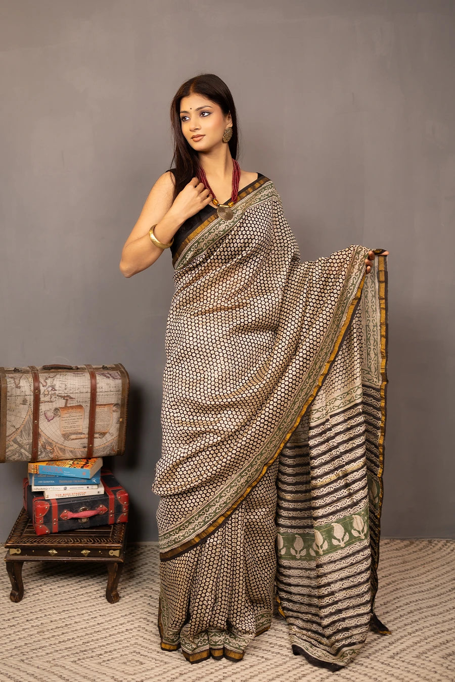 Woman wearing a patterned saree with a grey background