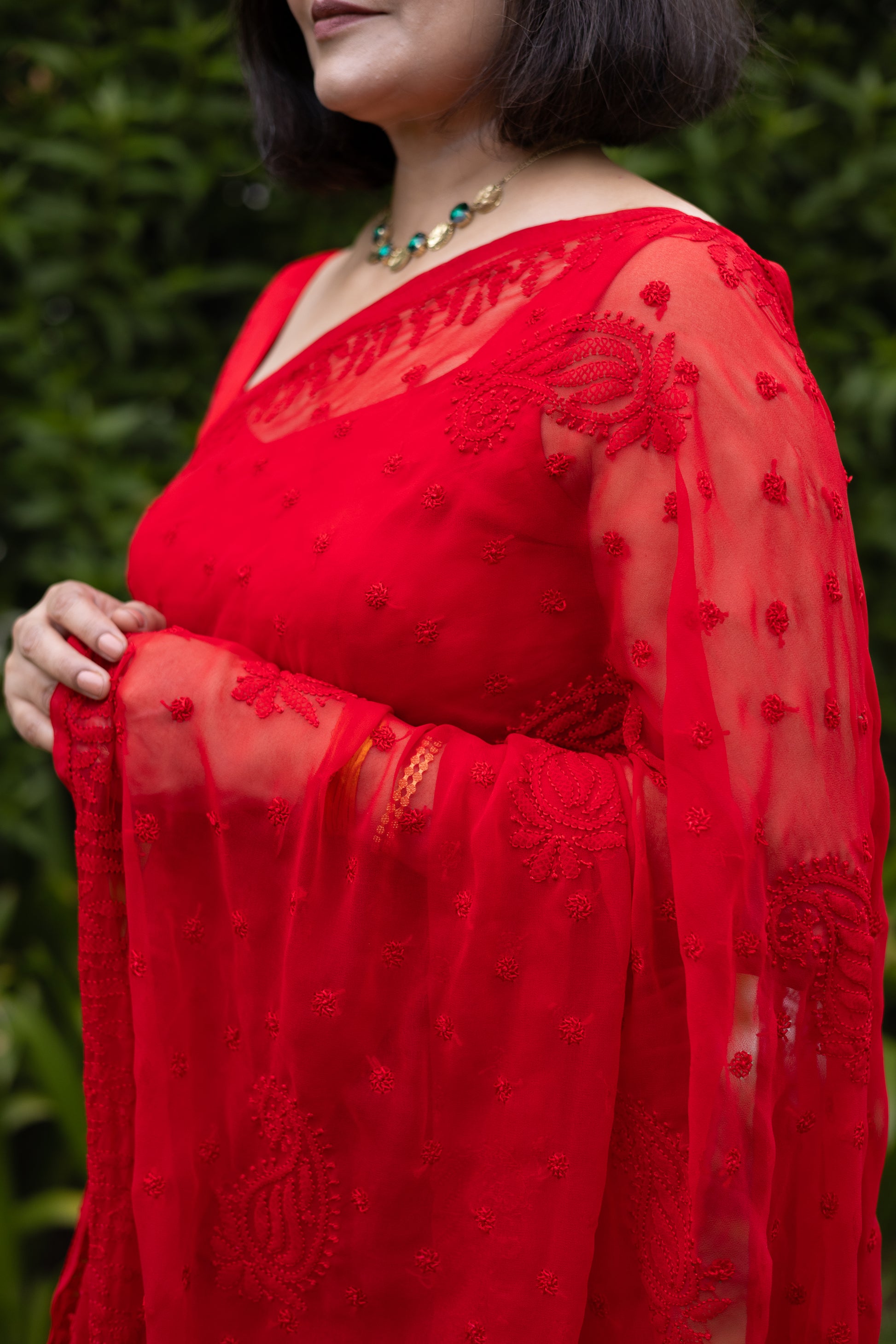 Detailed view of red chikankari embroidered sleeve on georgette saree blouse