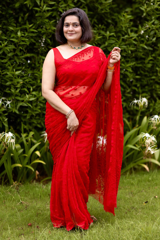 Woman wearing red georgette Lucknowi chikankari saree with blouse, front pose in garden