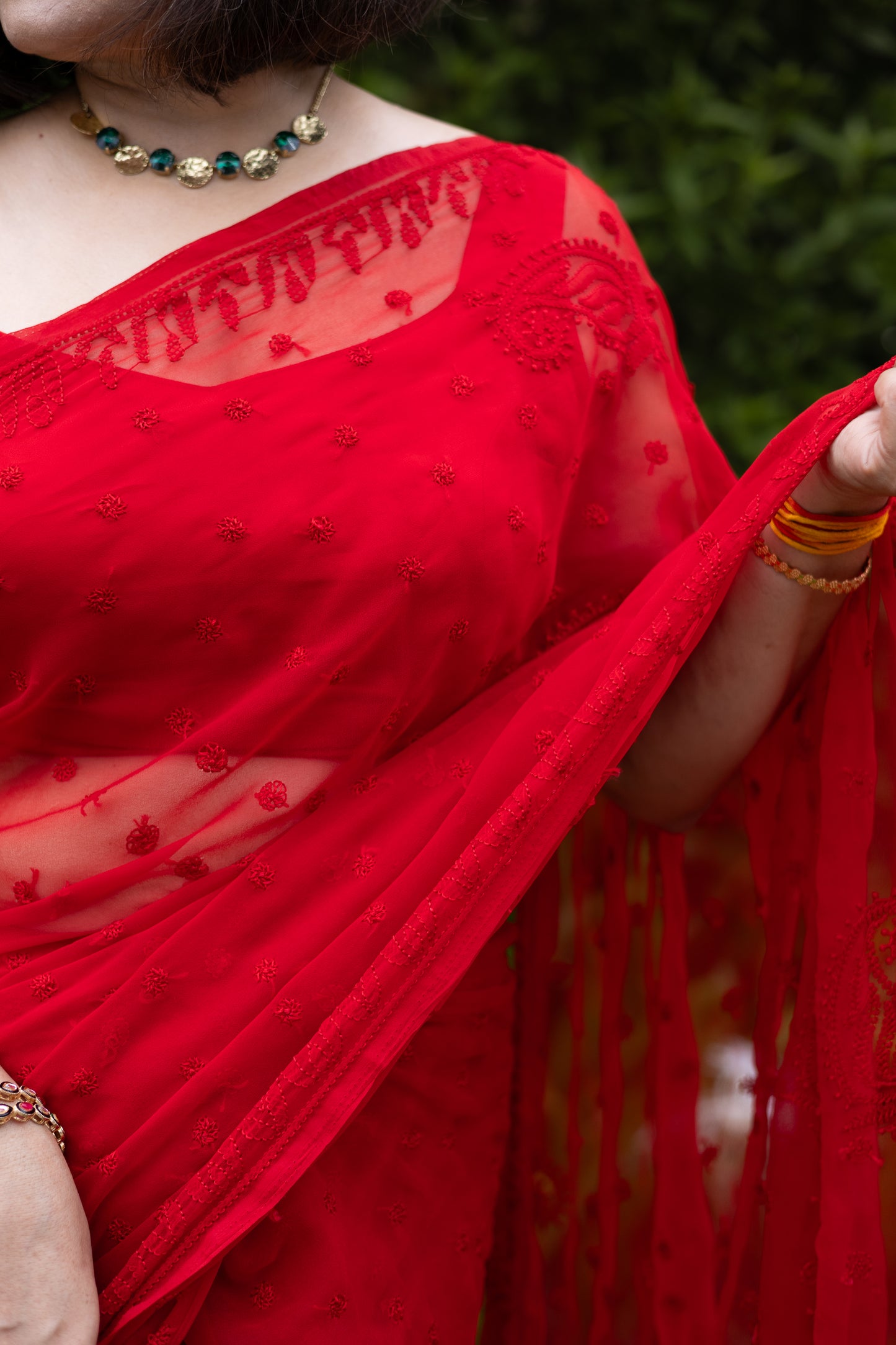 Close-up of red georgette Lucknowi chikankari hand embroidery on saree blouse neckline